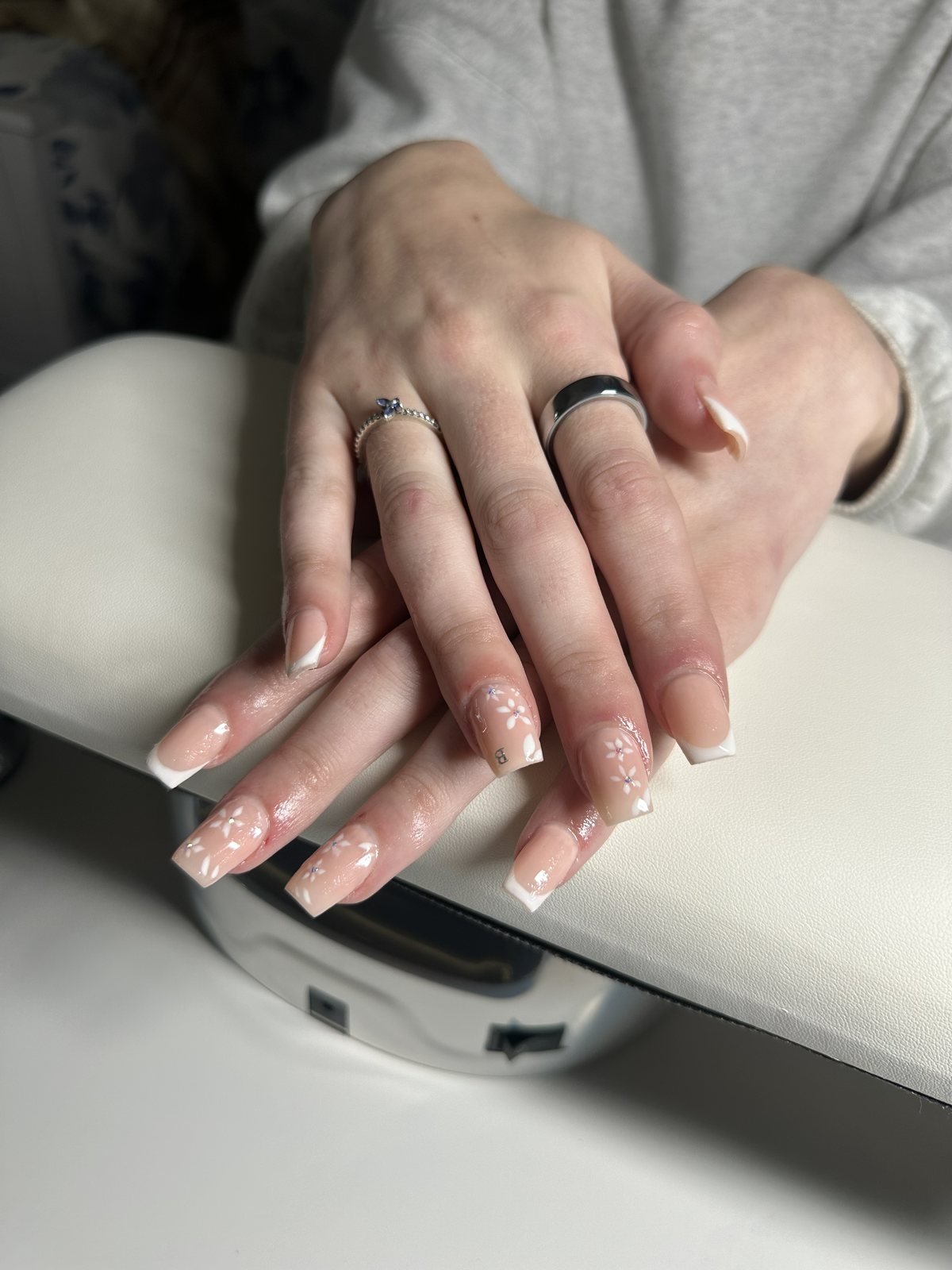 Long nude coffin acrylic set with white French tips and hand-painted floral accent nails